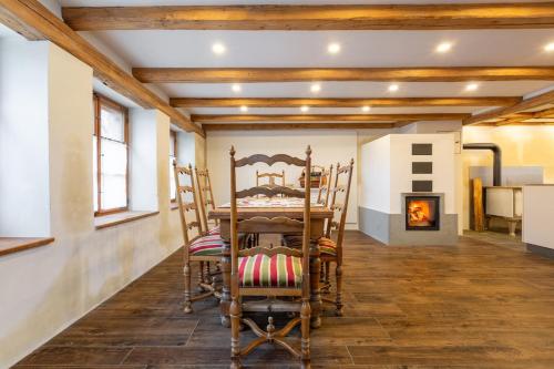 a dining room with a table and chairs and a fireplace at Living on a animal sanctuary in Schönenberg