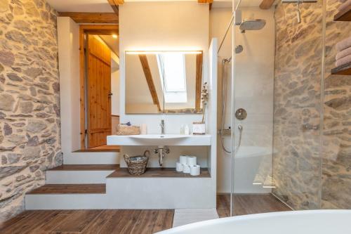 a bathroom with a sink and a mirror and a tub at Living on a animal sanctuary in Schönenberg