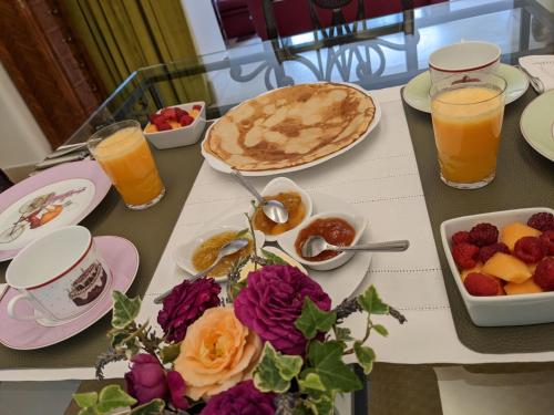 a table topped with plates of food and fruit at La Closerie in Droue-sur-Drouette