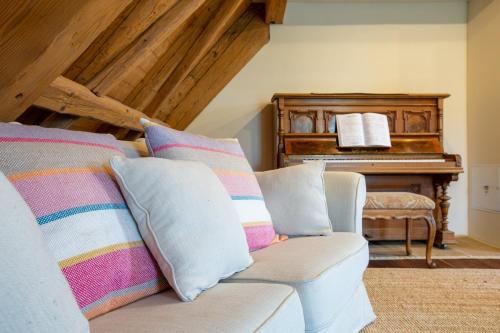 a living room with a couch and a piano at Living on a animal sanctuary in Schönenberg