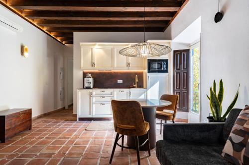 a kitchen and living room with a table and chairs at El Ladrón De Agua Palacete in Granada