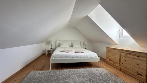 a bedroom with a white bed in a attic at The Sunset Spot in São Bartolomeu