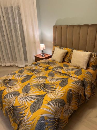 a bedroom with a bed with a yellow and black blanket at PERLA NOUACEUR AéROPORT MOHAMMED V in Nouaceur