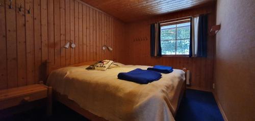 a bedroom with a bed with two blue towels on it at Sauna | Wi-Fi | Terrace | Wood stove | Cable TV in Lofsdalen
