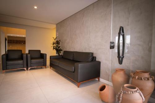 a waiting room with two black chairs and vases at Marezzi Hotel Aracaju in Aracaju