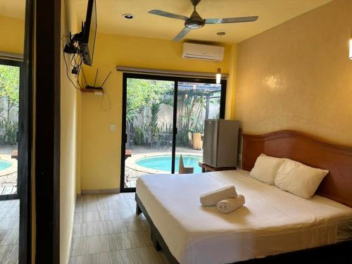 a bedroom with a bed with a ceiling fan at Casa la Roca Valladolid in Valladolid