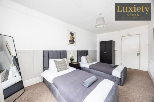 a hotel room with two beds and a mirror at Gorgeous & Stylish 3BR Home HIGH STREET LOCATION by Luxiety Stays Serviced Accommodation in Chelmsford