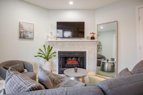 a living room with two couches and a fireplace at Cozy One Bed Apartment in Heart of Herndon in Herndon