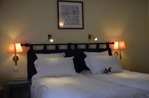 Кровать или кровати в номере Logis Hôtel Auberge du Cheval Blanc