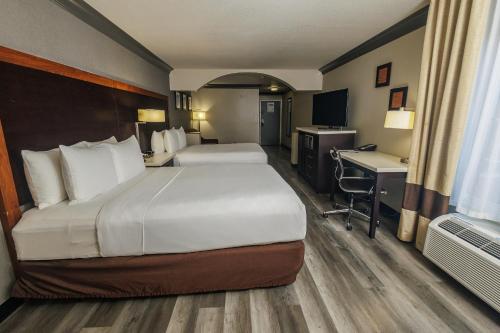 a hotel room with two beds and a desk at Comfort Inn & Suites Near Universal - N Hollywood - Burbank in Los Angeles