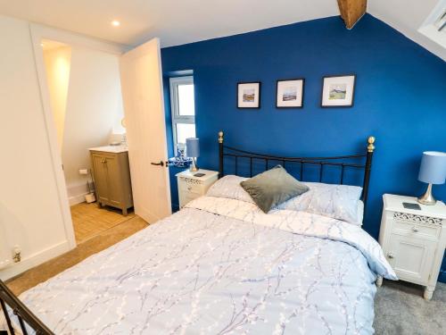 a bedroom with a blue wall and a bed at Seahaven in Maryport