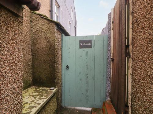 a green door in an alley between two buildings at Seahaven in Maryport