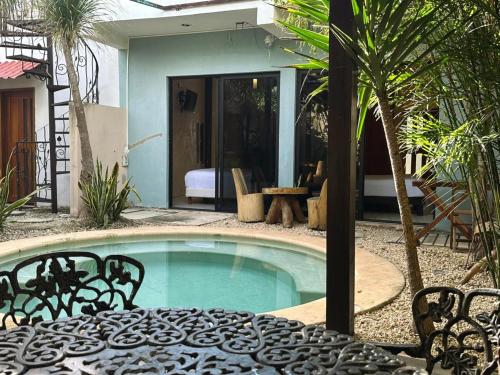 a swimming pool in a yard with chairs and a house at Casa la Roca Valladolid in Valladolid