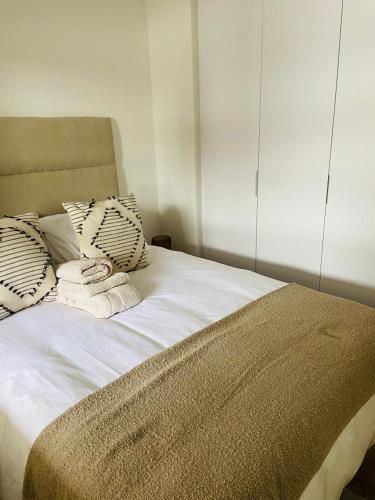 a bed with white sheets and pillows in a room at Le jardin 211 in George
