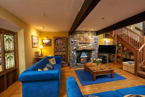 a living room with a blue couch and a fireplace at Canny Brow Barn in Kendal