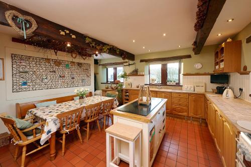 a kitchen with a table and chairs in a kitchen at Canny Brow Barn in Kendal