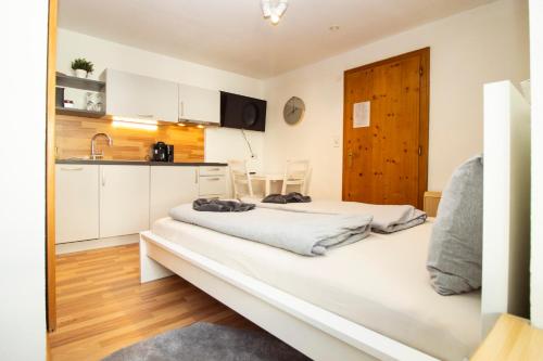 two beds in a room with a kitchen at Apartmenthaus ROSE in Prutz