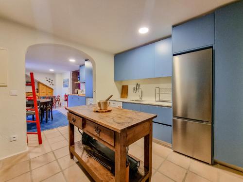 a kitchen with a wooden table and a refrigerator at Casa Justininho in Ponte de Lima