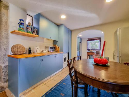 a kitchen and dining room with a wooden table at Casa Justininho in Ponte de Lima