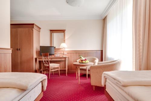 a hotel room with two beds and a table at Hotel Konradówka Wellness & SPA - 300 metrów do centrum in Karpacz