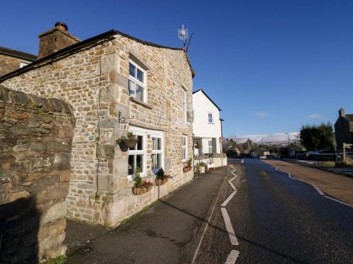 an old stone building on the side of a street at Holme Fell View in Sedbergh