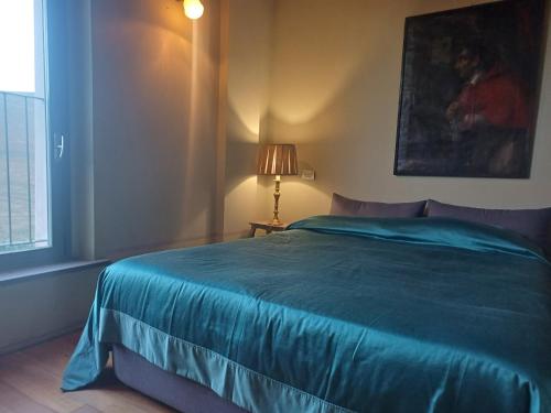 a bedroom with a blue bed and a window at Agriturismo CASA DELLE VIOLE in Fornovo di Taro