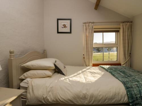 a bedroom with a bed and a window at Holme Fell View in Sedbergh