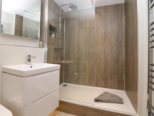 a bathroom with a white sink and a shower at Holme Fell View in Sedbergh