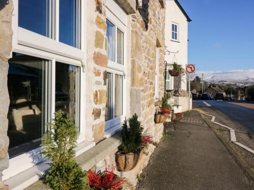 a building with potted plants on the side of a street at Holme Fell View in Sedbergh
