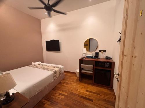 a bedroom with a bed and a desk with a mirror at Carnarvon Suites in George Town