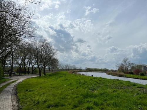 a grassy field with a path next to a river at Ferienwohnung Seegat in Emden