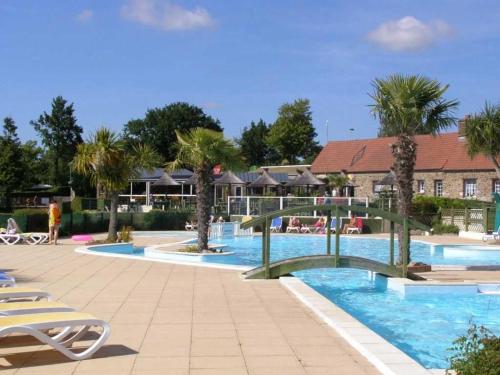 a swimming pool with palm trees in a resort at Camping 4 étoiles - Piscine - ccafgef in La Haye-du-Puits