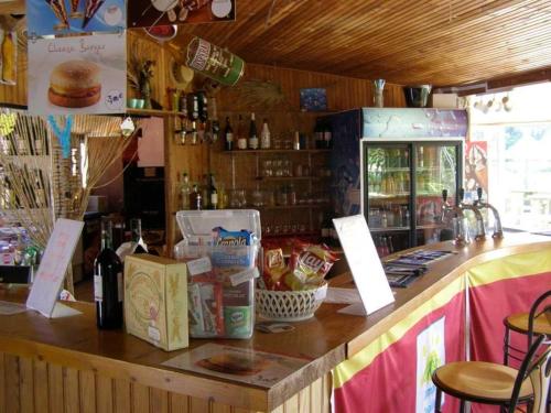 a restaurant with a counter with food and bottles of wine at Camping 4 étoiles - Piscine - ccafgef in La Haye-du-Puits