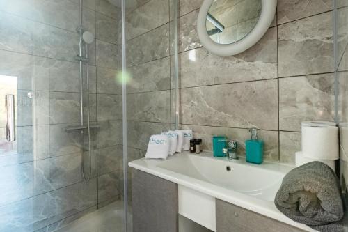 a bathroom with a shower and a sink and a mirror at Thea Luxury residences in Zakharo
