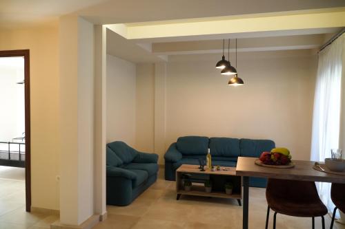 a living room with a blue couch and a table at Aether Home with view in Kalabaka
