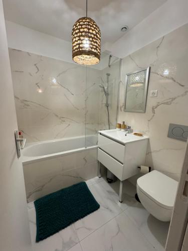 a bathroom with a sink and a toilet and a tub at La maison rouge proche de Paris in Fontenay-sous-Bois