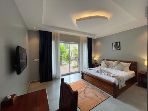 a bedroom with a bed and a large window at Sokchea Kampot Hotel in Kampot
