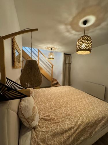 a bedroom with a bed and two chandeliers at La maison rouge proche de Paris in Fontenay-sous-Bois