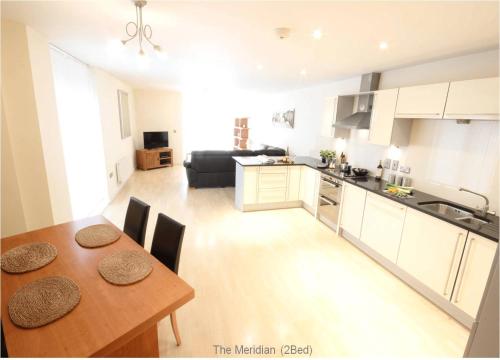 a kitchen and living room with a wooden table and a dining room at Reading Spacious Two Bedroom Apartment in Reading