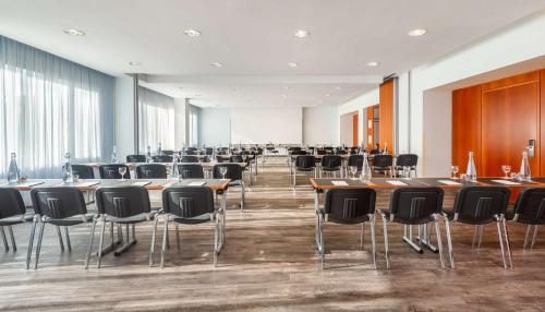 an empty conference room with tables and chairs at Radisson Blu Fürst Leopold Hotel in Dessau