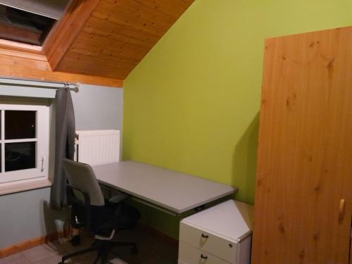 a desk in a room with a green wall at Chambre au coeur de la Gaume - Chambre 3 Vert-Jaune in Virton