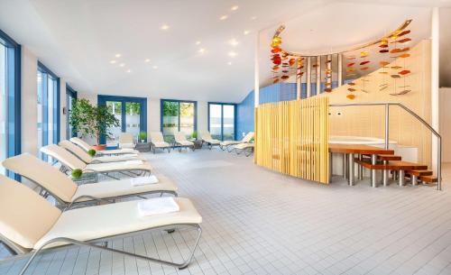 a room with chairs and a table and a staircase at Radisson Blu Fürst Leopold Hotel in Dessau