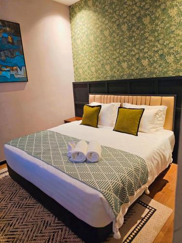 a bedroom with a bed with two towels on it at Carnarvon Suites in George Town
