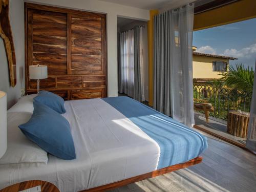 a bedroom with a bed and a large window at Suites La Hacienda in Puerto Escondido
