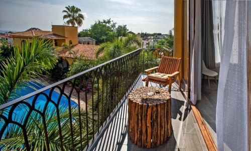 a balcony with a chair and a tree stump at Suites La Hacienda in Puerto Escondido