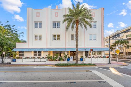 Un gran edificio blanco con una palmera delante. en Beach Plaza, en Miami Beach