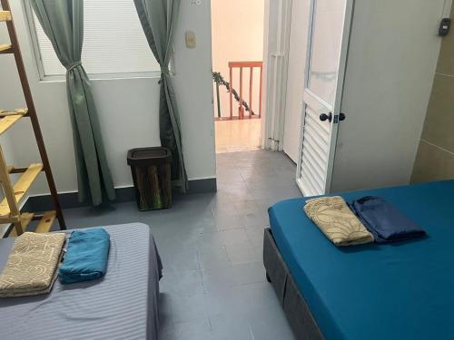 two beds sitting in a room with a door at Habitación cerca de la playa 203 in Cartagena de Indias