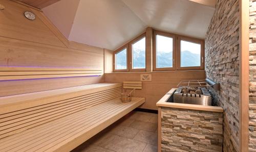 a sauna with wooden benches and a stone wall at Alphotel Innsbruck in Innsbruck