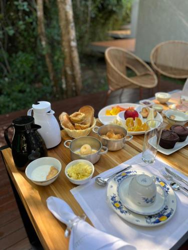 uma mesa de madeira coberta com pratos e tigelas de comida em Amaná Hotel em Sao Jorge