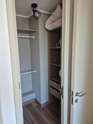 a walk in closet with shelves and a door at Hermoso Departamento Céntrico con Estacionamiento in Concepción